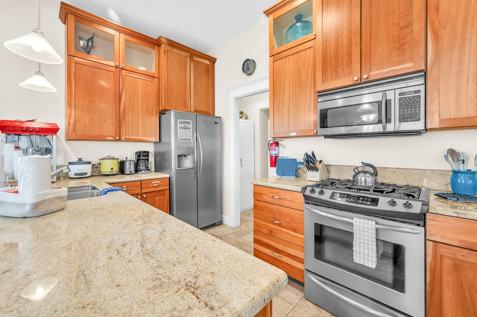 Your fully equipped kitchen features granite countertops, stainless steel appliances, and warm wood cabinetry—perfect for preparing meals together during your stay.
