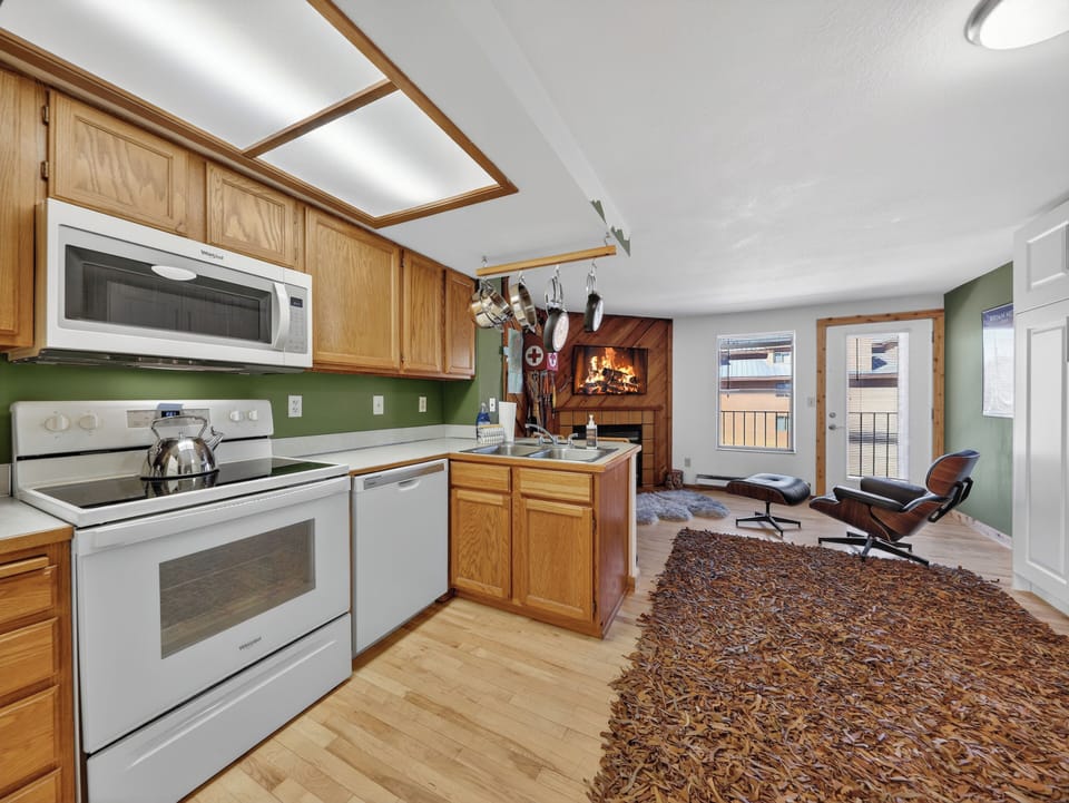 Cozy up in your open-concept retreat where the kitchen flows seamlessly into your living space, complete with a crackling fireplace for perfect mountain evenings.