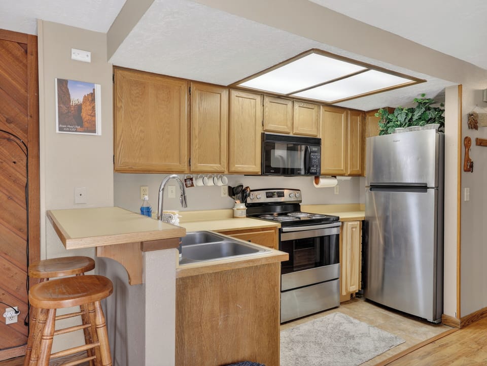Your fully equipped kitchen features stainless steel appliances and warm wood cabinetry, perfect for preparing meals during your stay.