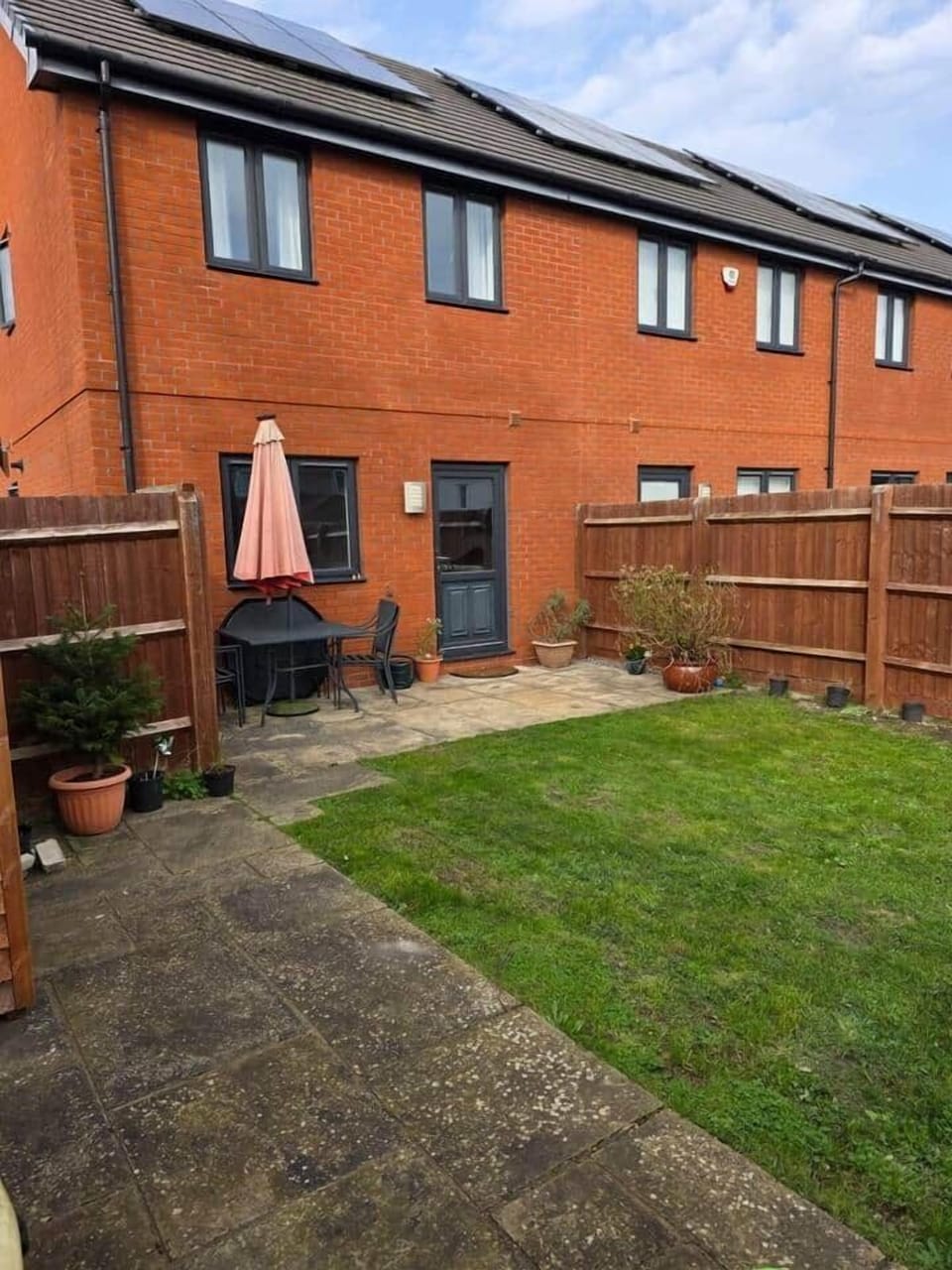 The rear of the property has a well-maintained private garden with outdoor furniture for relaxation and dining.