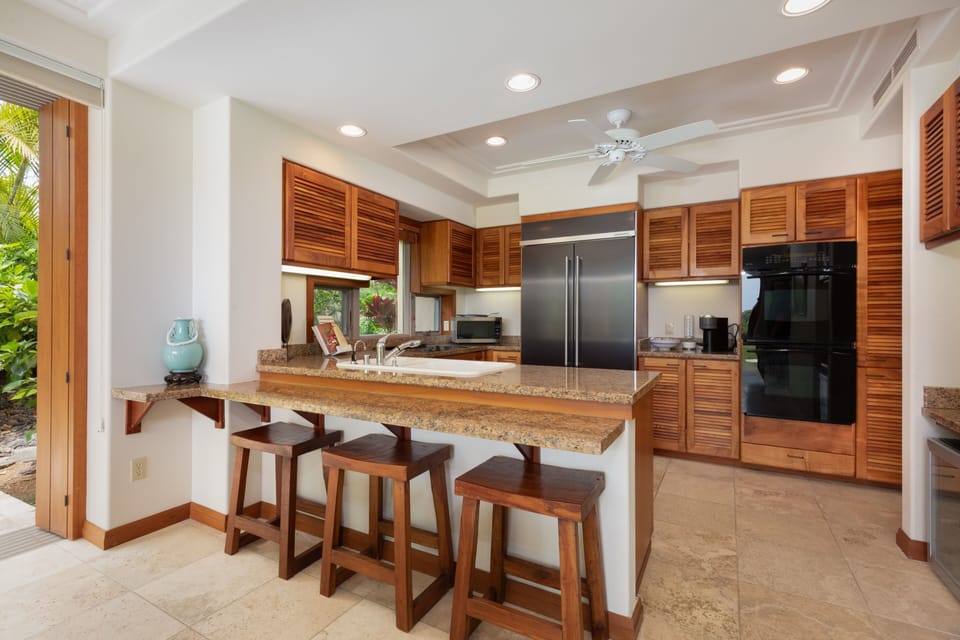 Your fully equipped kitchen features granite counters, stainless appliances, and a breakfast bar perfect for morning coffee.
