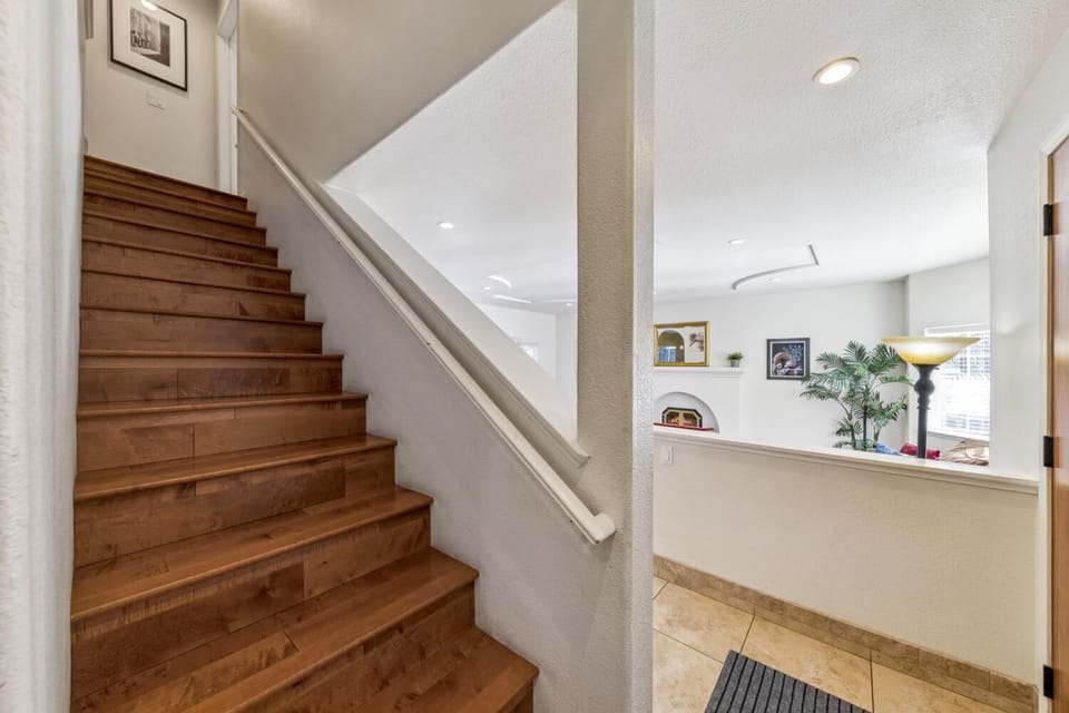 Warm wooden staircase leading to a bright, open living area