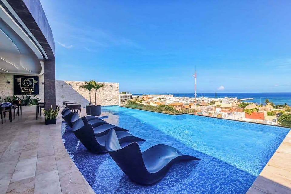 Shared rooftop infinity pool with ocean and town views