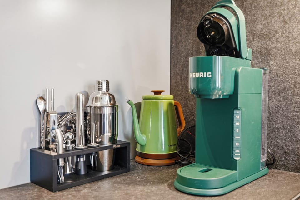 Stylish beverage nook with Keurig, kettle, and complete cocktail set.