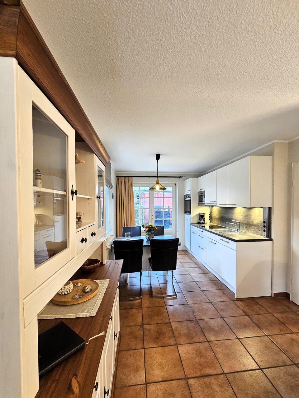 Modern kitchen with dining area and view outside.