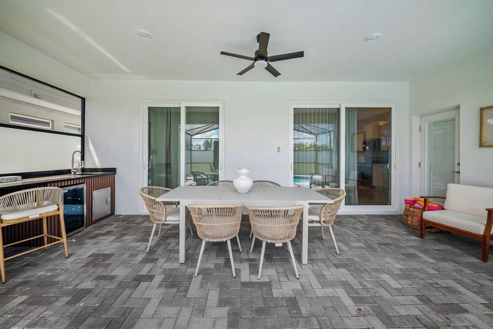 Experience a stylish dining area that combines comfort and function, featuring a spacious table with chic wicker chairs. Natural light floods in through sliding doors, creating a welcoming atmosphere ideal for gatherings.
