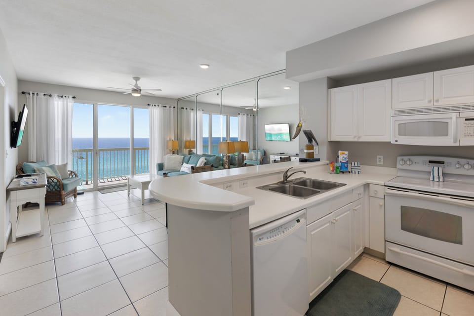 Your fully equipped kitchen opens to a bright living space with breathtaking sea views through floor-to-ceiling windows.