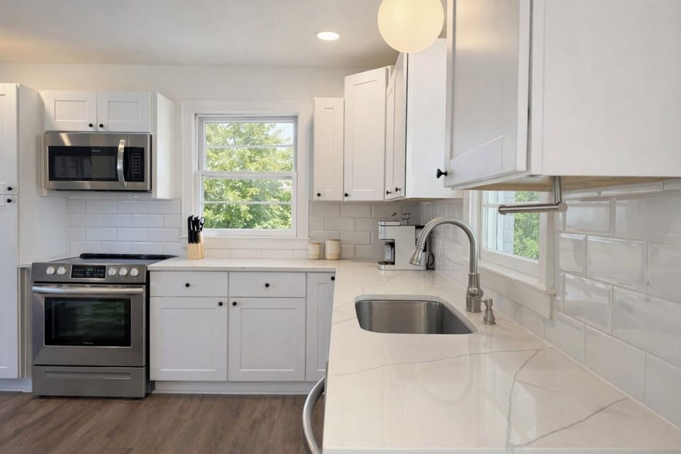 Bright, streamlined kitchen. Stainless, microwave, deep sink, calm design.