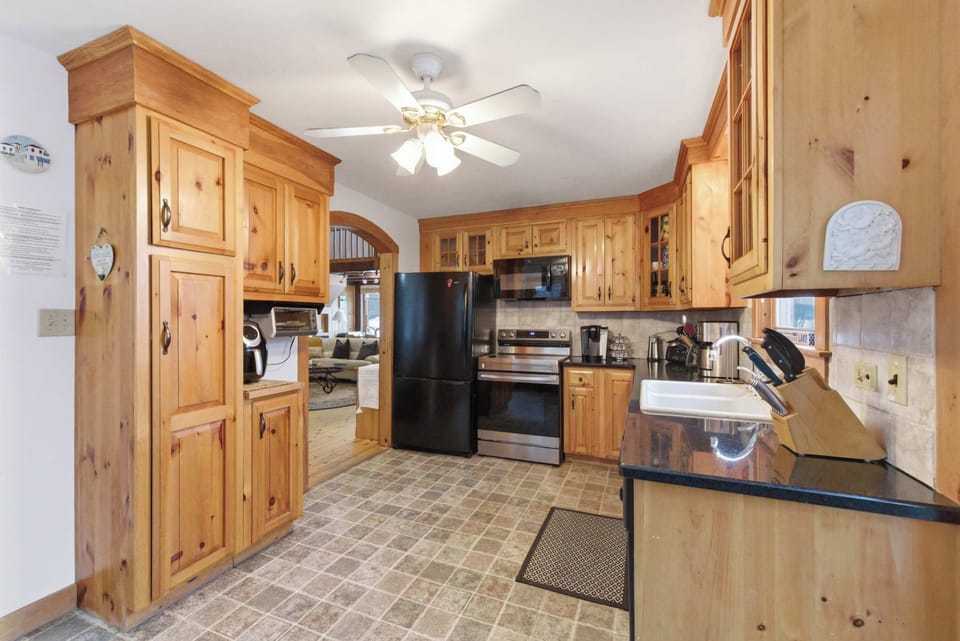 The kitchen has room to move — knotty pine cabinetry, full-size appliances, and enough counter space for a real group meal.