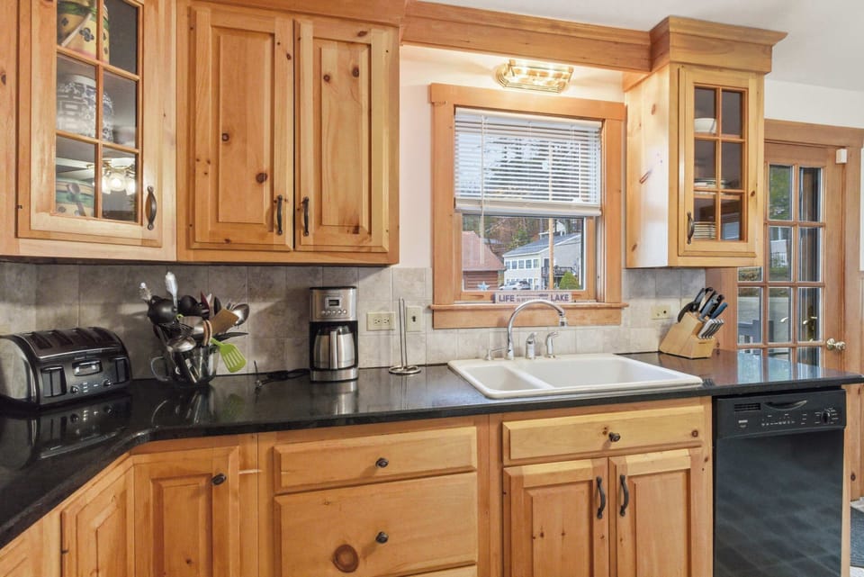 Electric range, deep sink, and dark countertops keep the kitchen practical without sacrificing warmth.