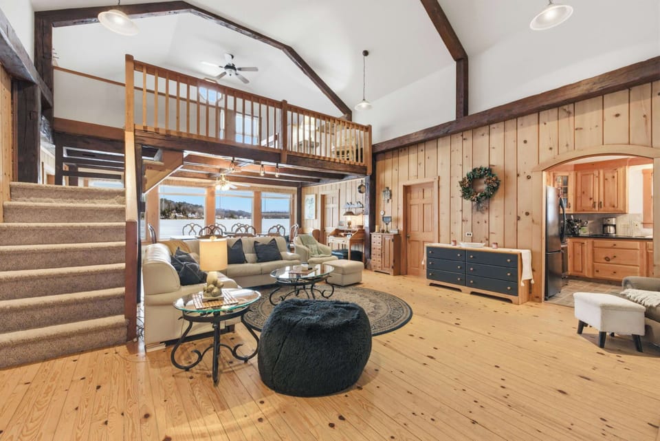 The great room from the kitchen side shows the staircase up to Loft 1 and the full open flow of the main living area.