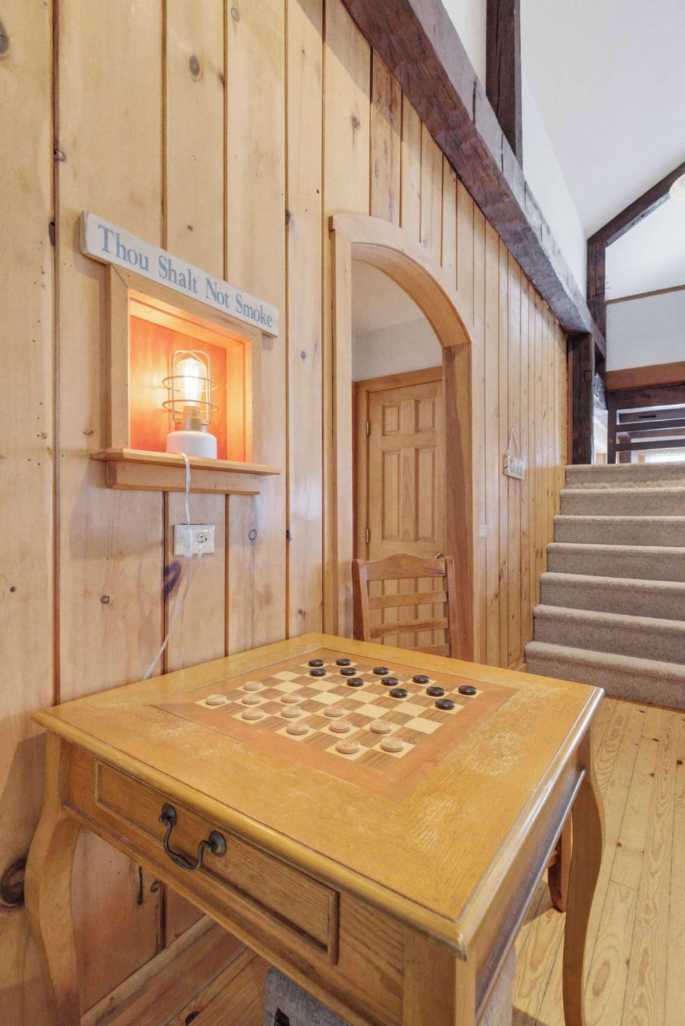 The checker table nook tucks into an arched alcove just off the living area — one of those details that gives the house its character.
