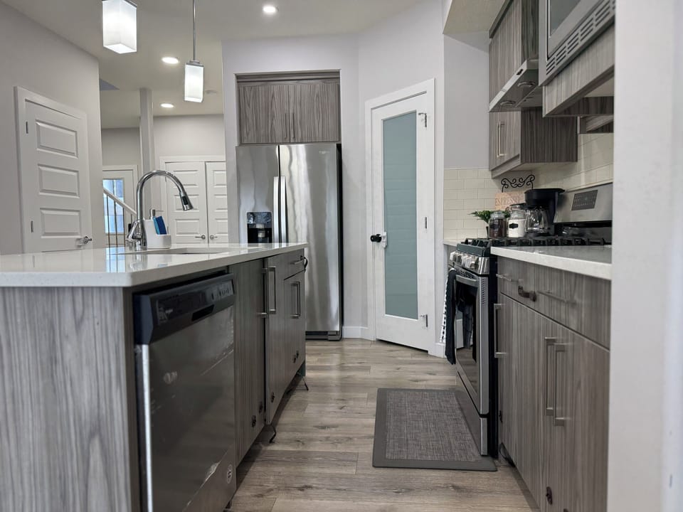 Modern kitchen with stainless steel appliances—fridge, microwave, dishwasher, and a gas stove for effortless cooking.