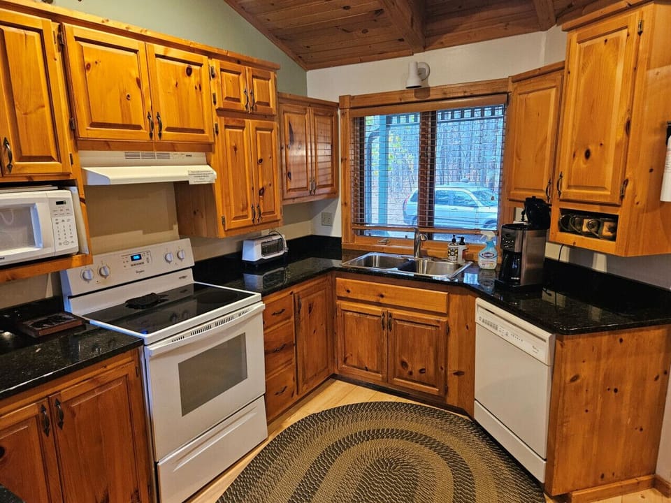 Cook with ease in this warm kitchen featuring rich wood cabinets, granite counters, and all essential appliances for memorable meal prep.