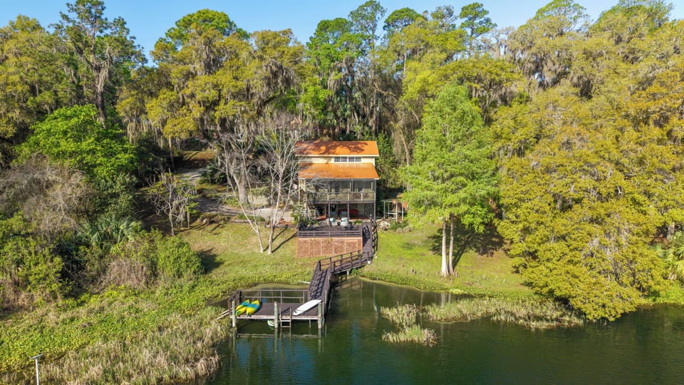 View of the dock, deck, and house from the water