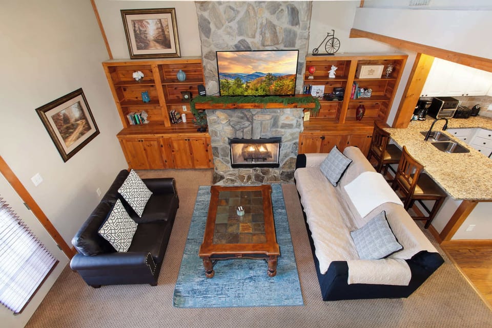 Cozy living room with stone fireplace and TV.