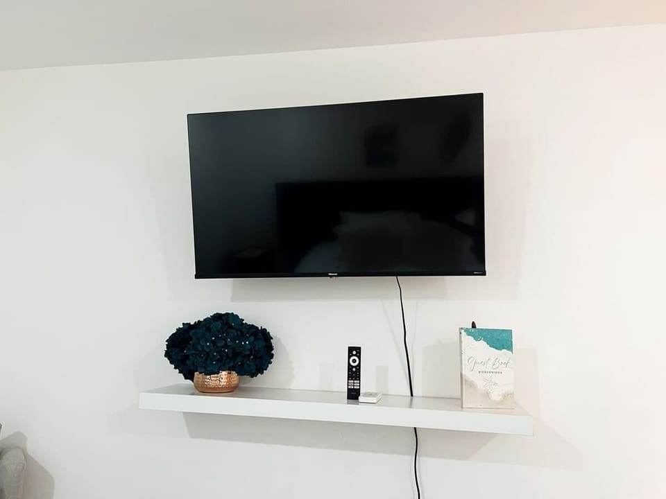 Minimal TV wall setup w/ clean lines & simple decorative accents