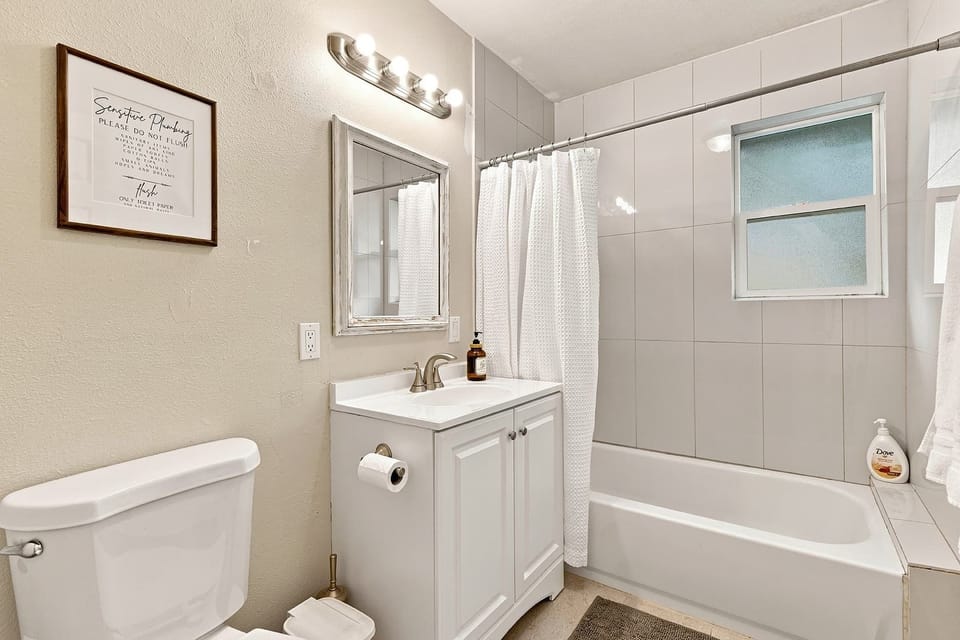 A full bathroom with a vanity and tub-shower combination.