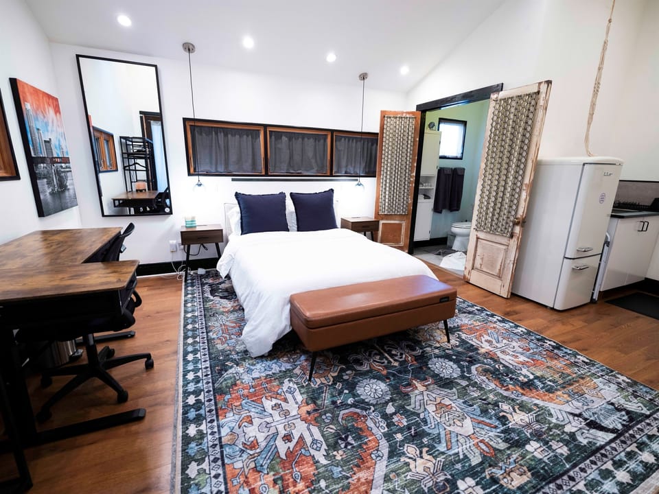Modern studio setup with bed, TV & dedicated workspace for comfort and productivity