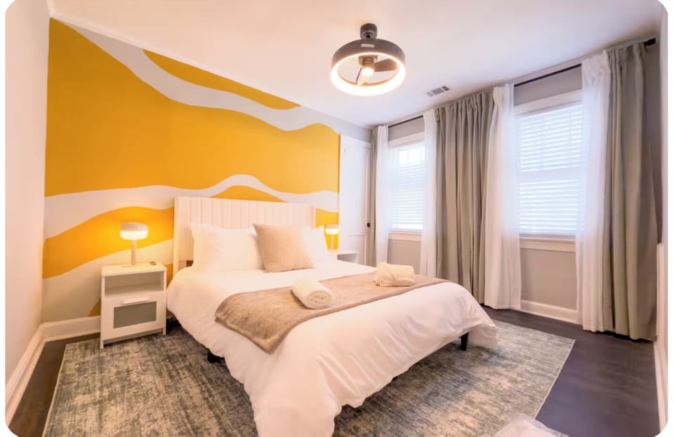 Comfortable bedroom with a queen bed, bold mural wall and natural light