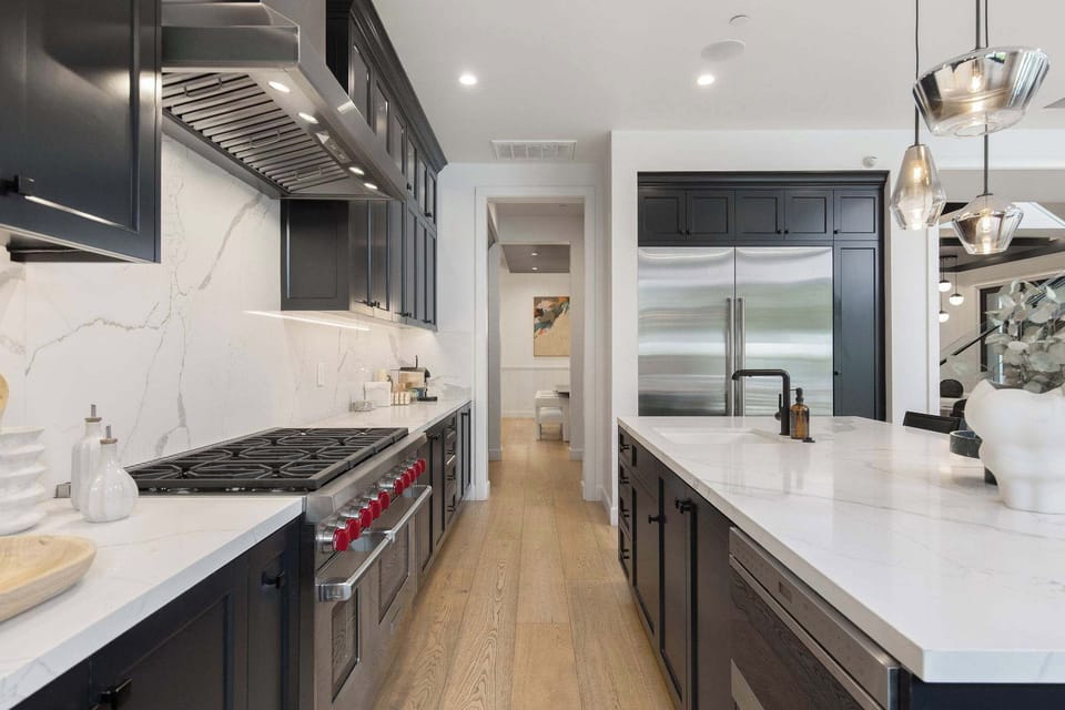 A chef’s kitchen with oversized island, premium appliances, and modern farmhouse design