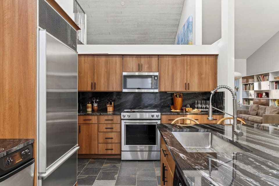 Sleek kitchen workspace with a professional gas range and microwave.