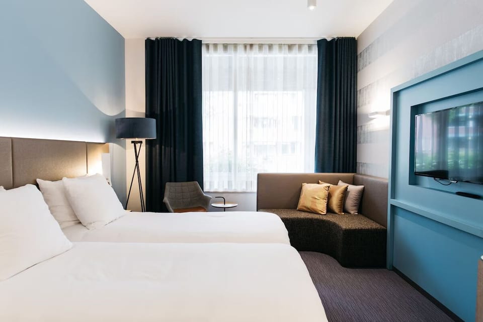 Settle into crisp linens beside a sunlit window lounge.