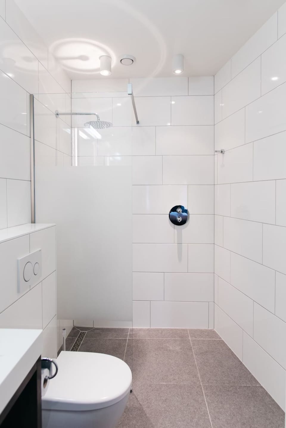 Refresh under a sleek rain shower in a spotless space.