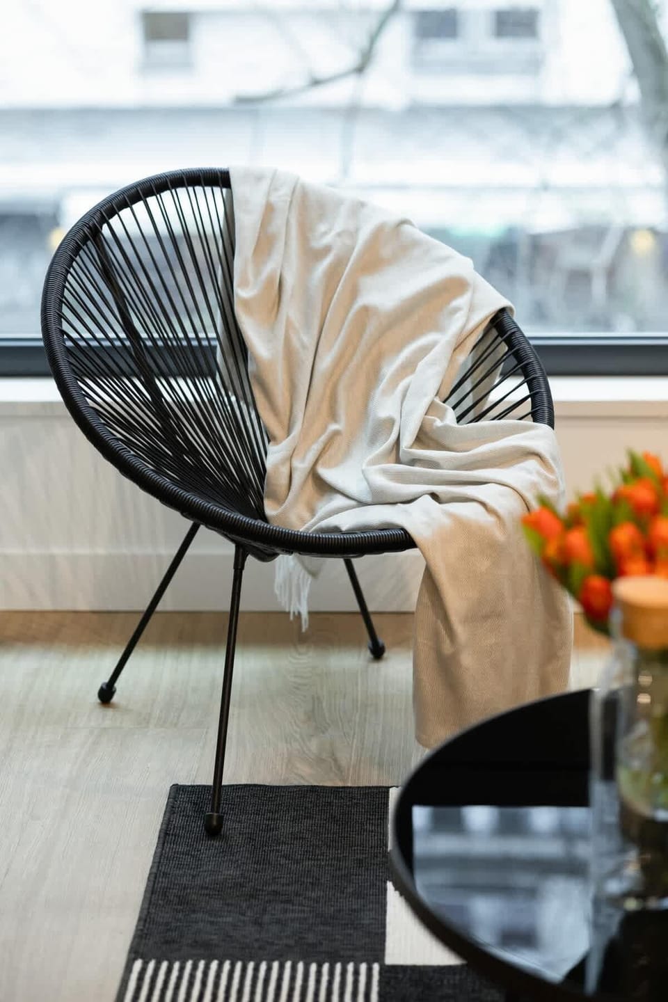 Minimalist reading corner with a stylish chair, side table, and a potted plant.