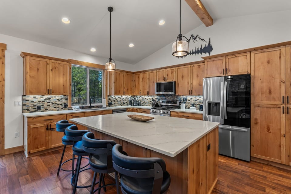 Gather around this spacious kitchen island where you'll whip up memorable meals with modern appliances and warm wood cabinetry.
