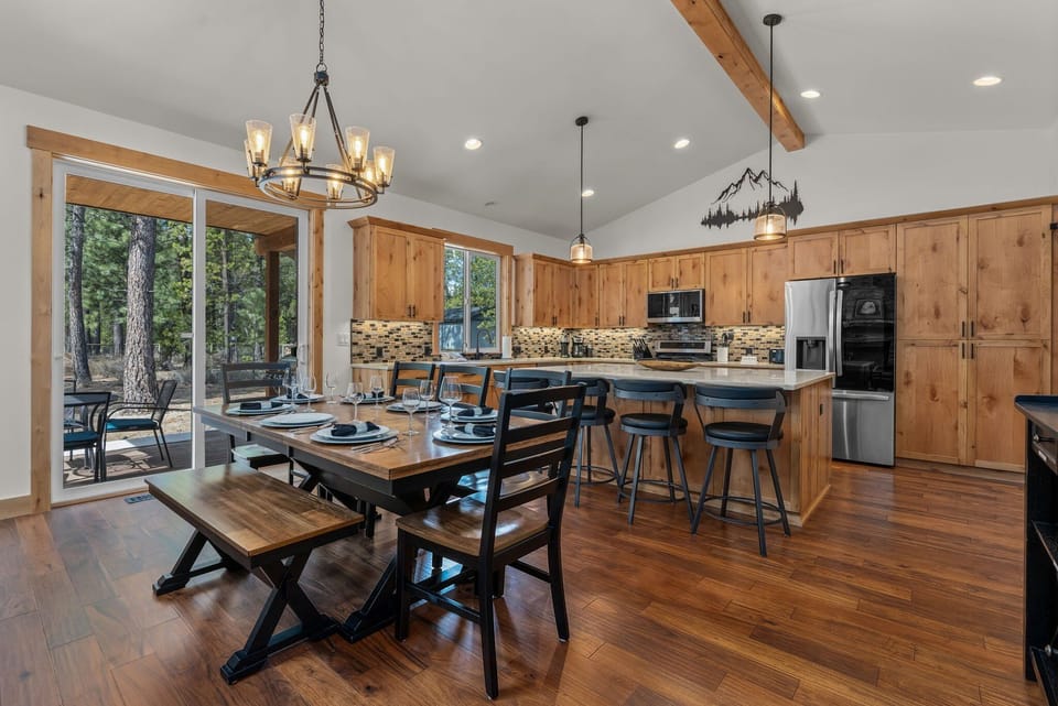 Cook and dine together in this spacious mountain kitchen with warm wood details, modern appliances, and forest views from your deck.