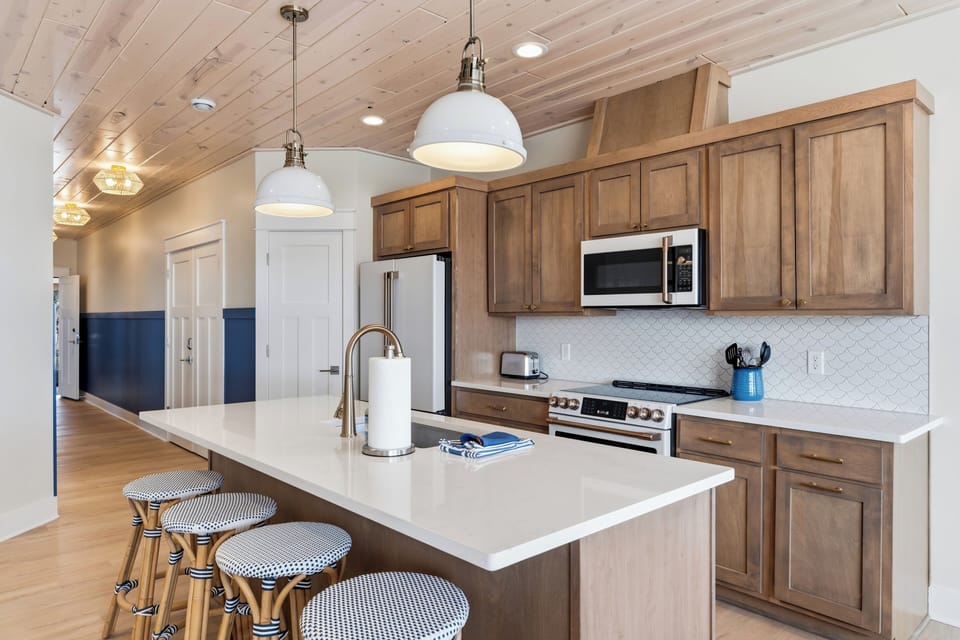 Fully equipped gourmet kitchen with quartz countertops and bar seating
