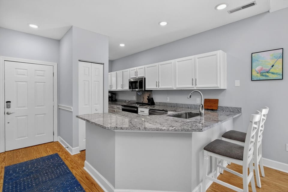 Your modern kitchen features granite countertops, stainless appliances, and a breakfast bar perfect for morning coffee or casual meals.