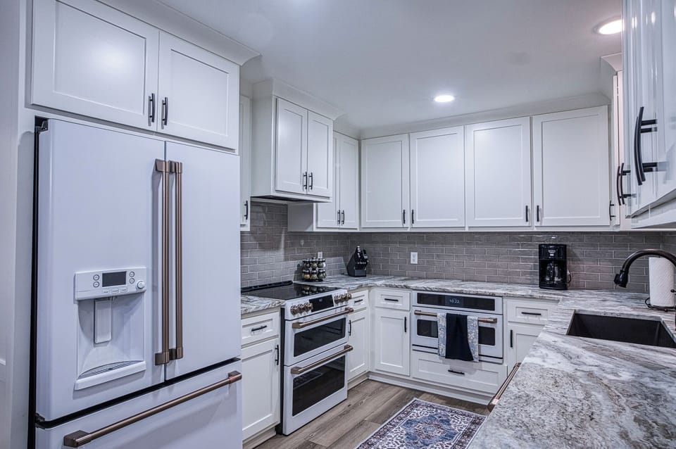Step into your gourmet kitchen with pristine white cabinets, stunning granite counters, and premium stainless appliances ready for your culinary adventures.