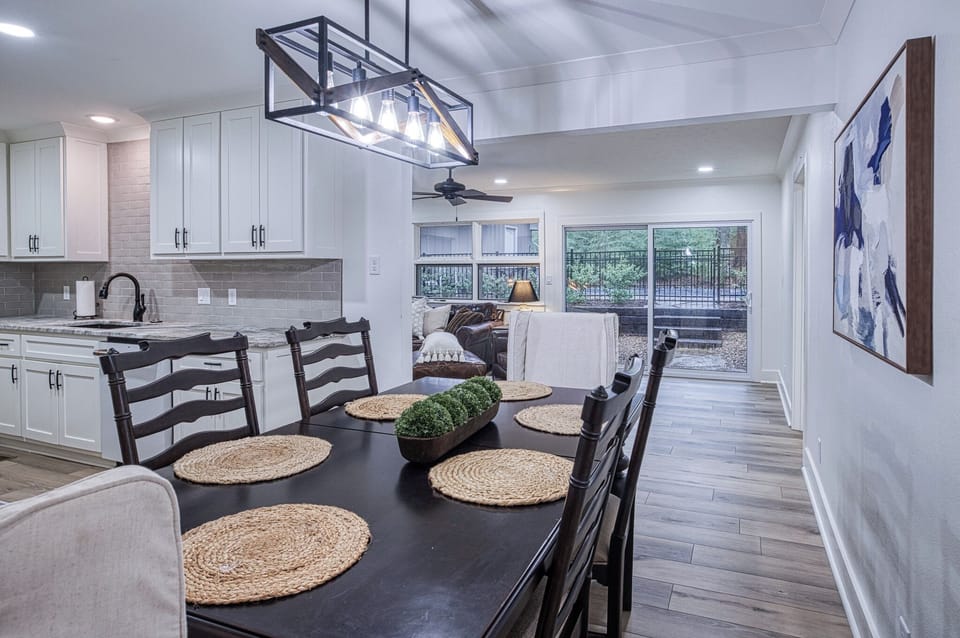 Your open-concept kitchen and dining space features elegant lighting, modern appliances, and natural light flowing through large windows.