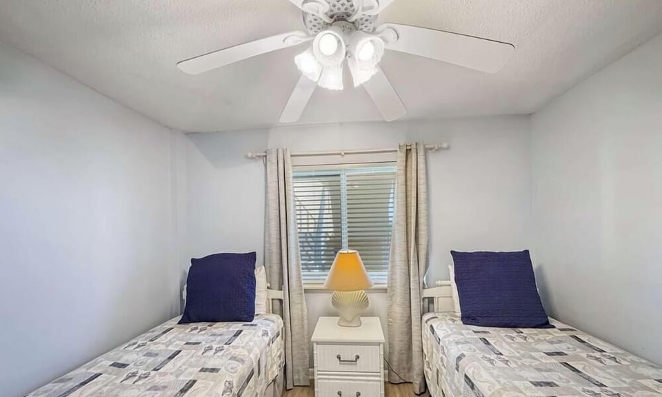 The second bedroom offers a TV & a pair of cozy twin beds​