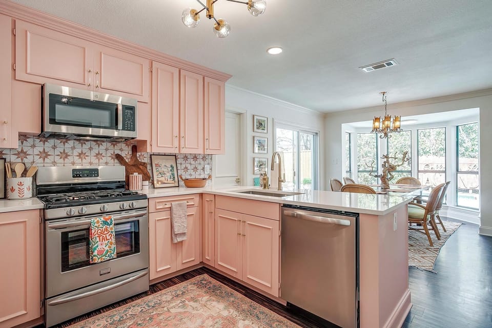 Full-size gas range, stainless appliances, and pink cabinets that mean business. Cook together or just look good doing it.
