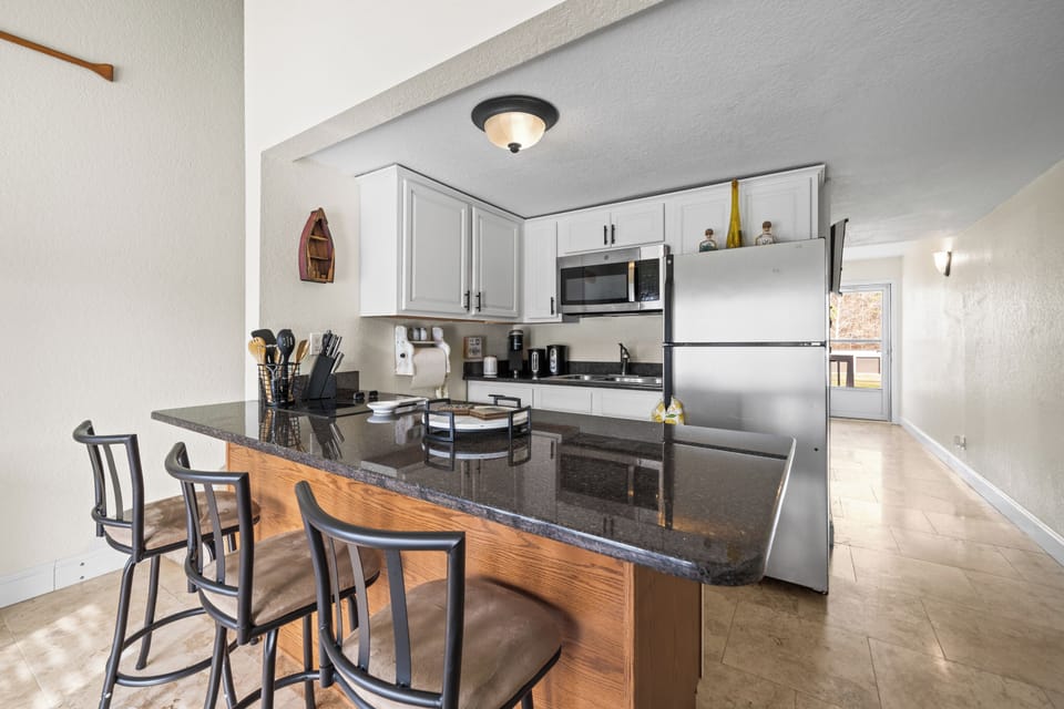 Spacious kitchen with a large granite bar and seating.