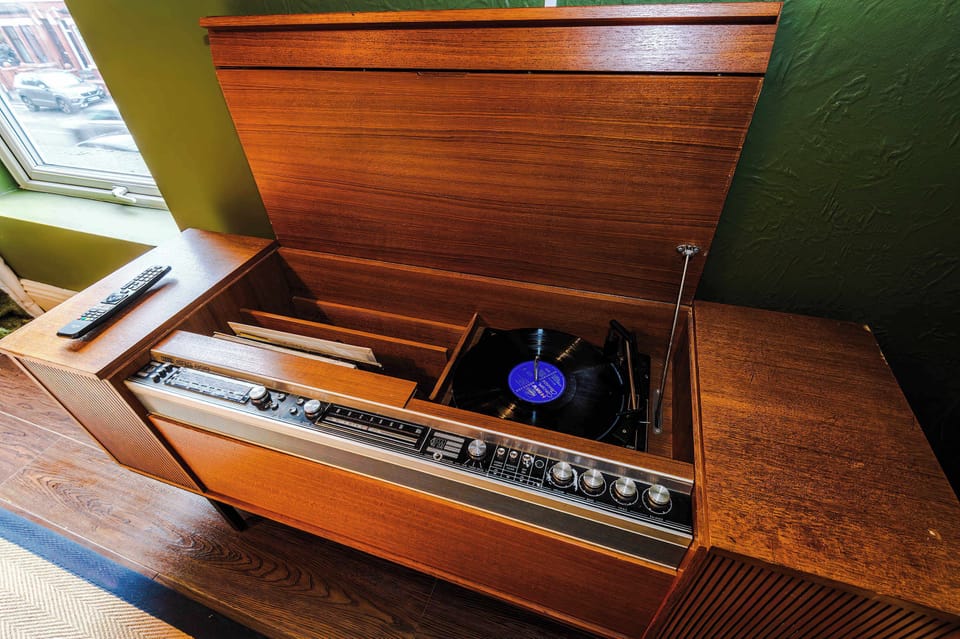 The retro styled living room features a large corner sofa, perfect for relaxing in the evening. The ambience of the room is a total experience, allowing you to relax with a good book or appreciate the tasteful artwork and enjoy some records playing!