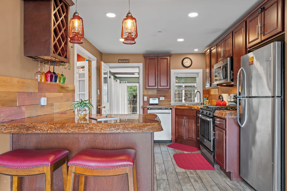 Warm kitchen w/ granite, stainless, gas range & breakfast bar