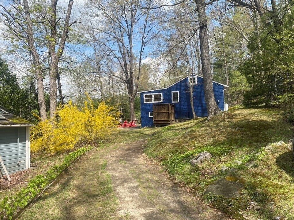 Driveway with view of cottage including outdoor shower