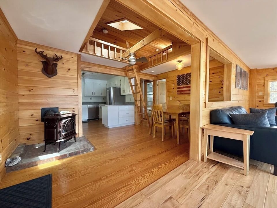 ladder to sleeping loft, table for 4, kitchen, gas fireplace, doors to bedrooms