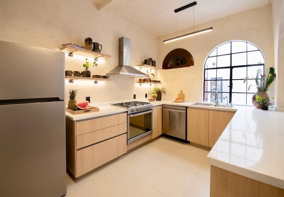 A bright, thoughtfully designed space with clean lines and warm wood finishes. Open shelving, generous counters, and natural light create a welcoming setting that feels both practical and refined for everyday use.