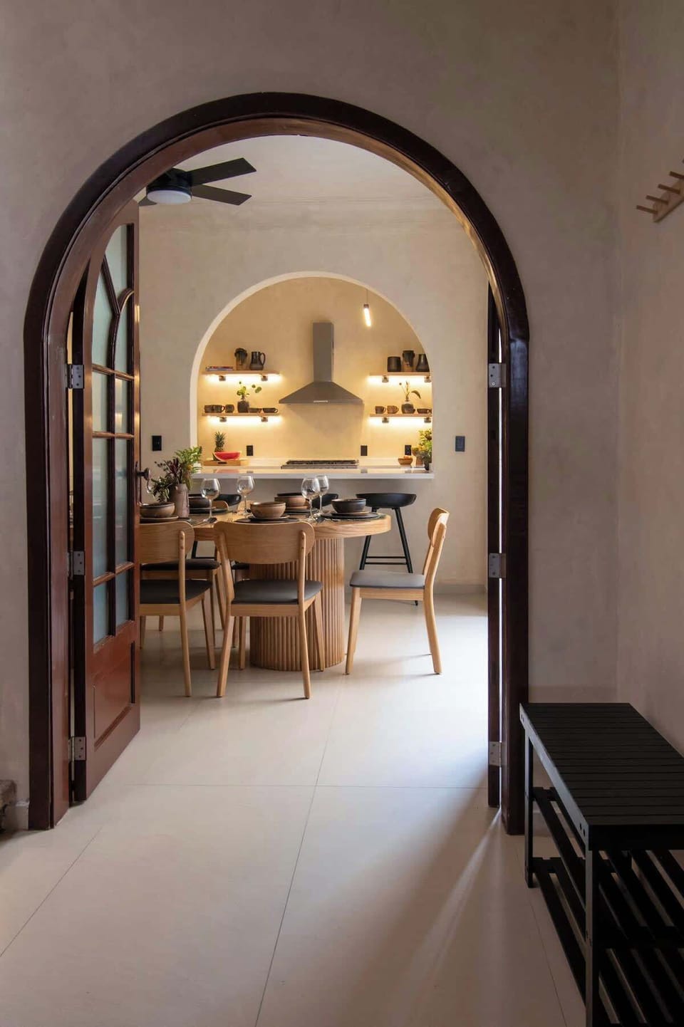 A graceful arched entry framing the dining area and beyond. Warm wood details and soft lighting guide the eye through the space, creating a welcoming transition that feels elegant and thoughtfully designed.