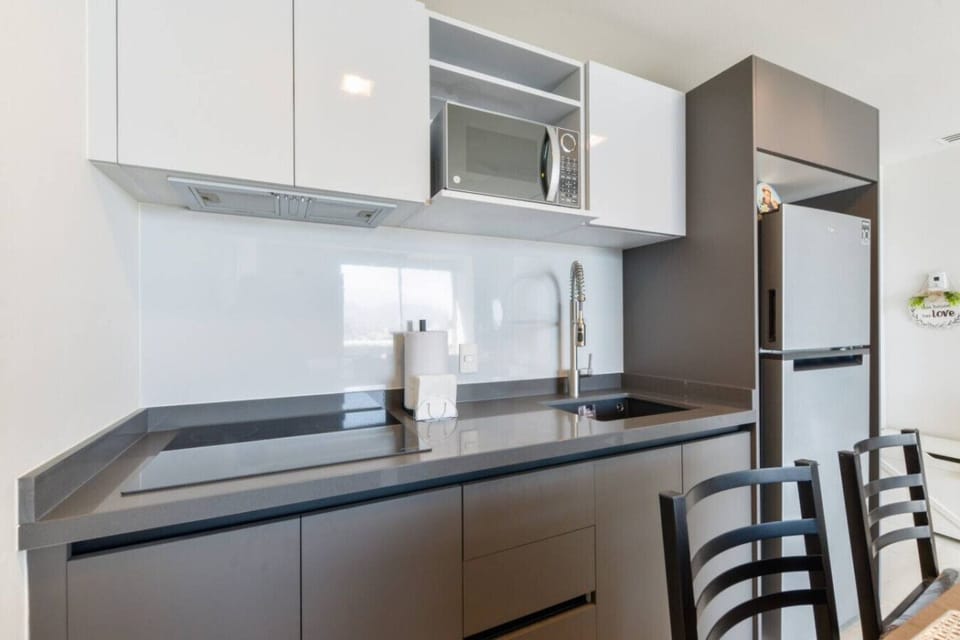 Cocina equipada con refrigerador, estufa, cafetera y licuadora, perfecta para preparar tus alimentos con comodidad durante tu estancia.