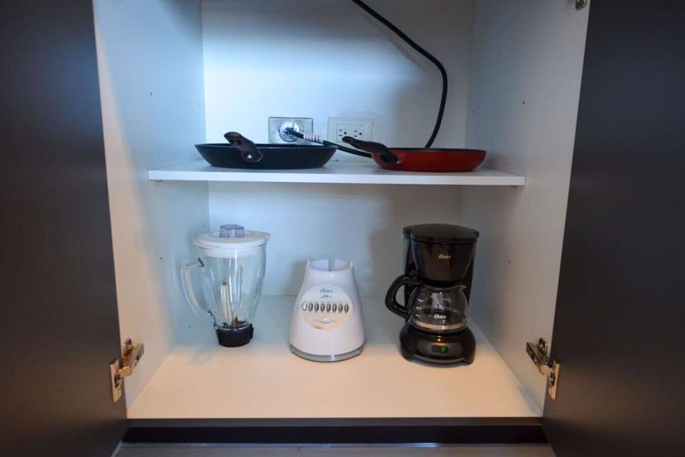Cocina equipada con refrigerador, estufa, cafetera y licuadora, perfecta para preparar tus alimentos con comodidad durante tu estancia.