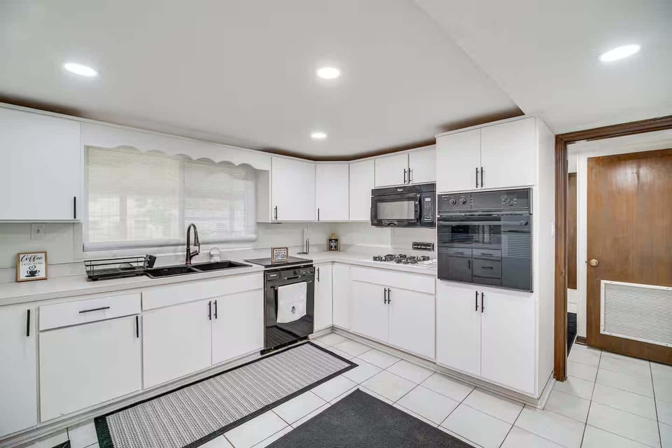 Modern kitchen with white cabinetry and black appliances for a clean look.