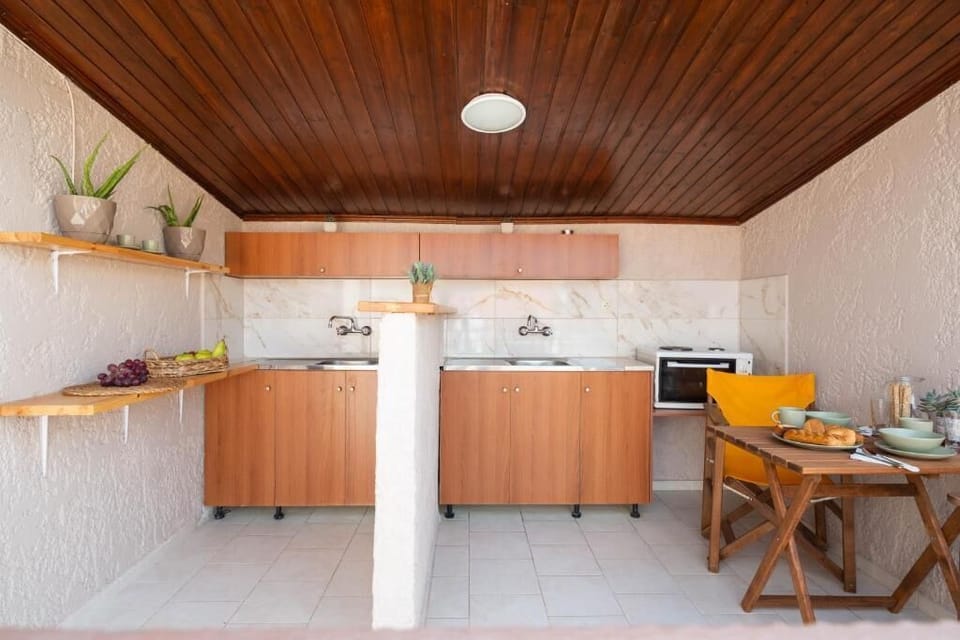 Functional kitchenette with warm wooden accents and a cozy dining area. Ideal for preparing meals and enjoying dinners with your loved ones