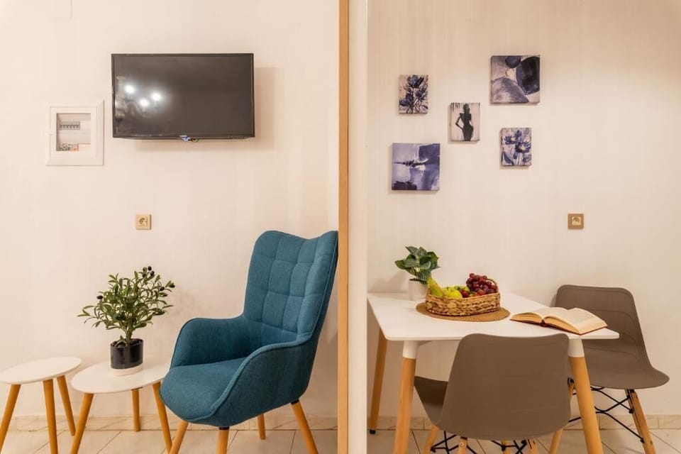 Cozy and stylish dining area featuring a sleek table, a TV, comfortable chairs, and a relaxing armchair. A perfect spot to enjoy breakfast, unwind, or spend quality time indoors