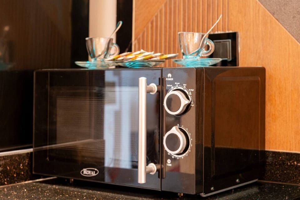 Appareils modernes : réfrigérateur, micro-ondes, four, plaques de cuisson.